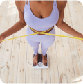 A woman measuring her waist with a tape measure, focusing on her body measurements for fitness or health purposes