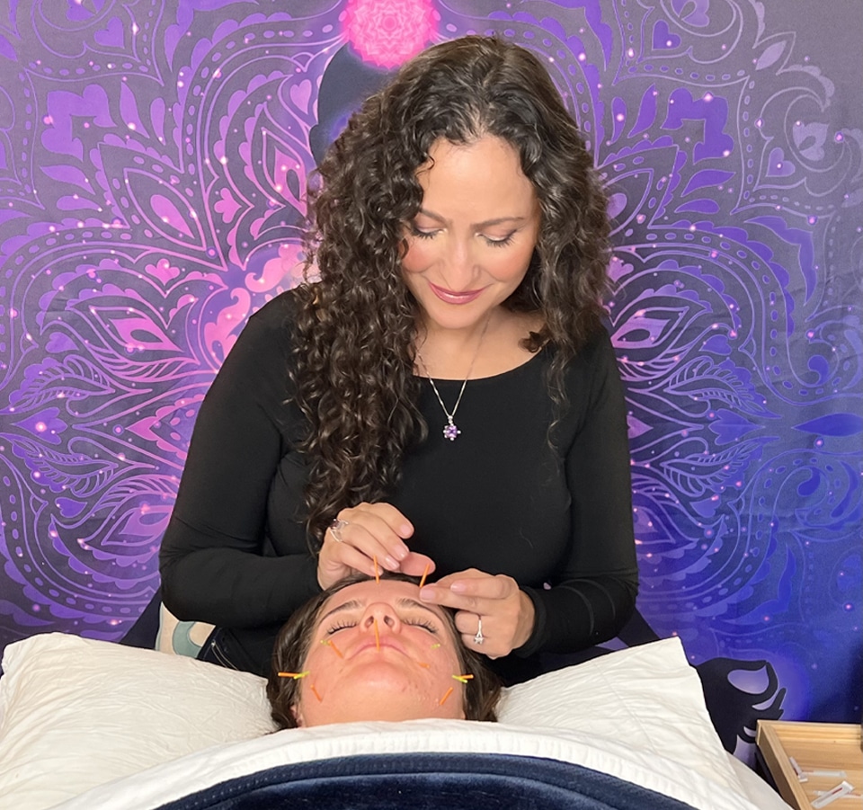 Parisa performing acupuncture on a client, demonstrating a professional and calming treatment environment